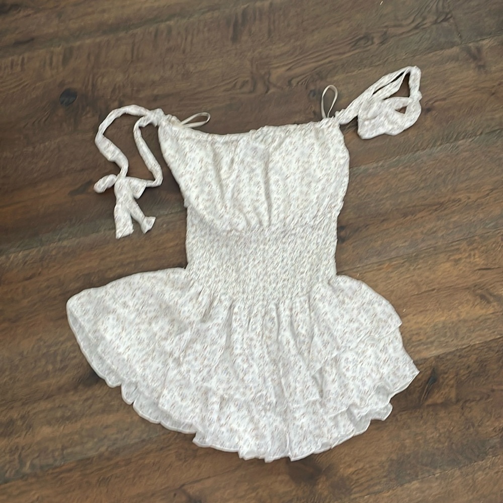 floral white romper. Never worn. Straps can be over shoulders or to the side.